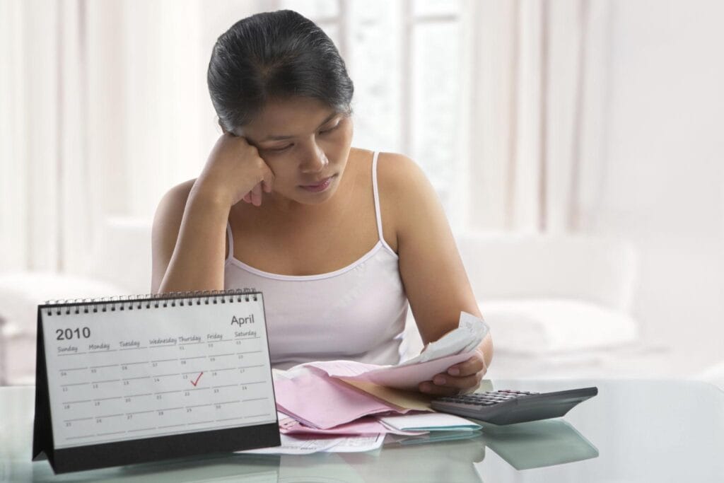 Pessoa analisando boletos e contas para entender se uma dívida prescreve depois de 5 anos.