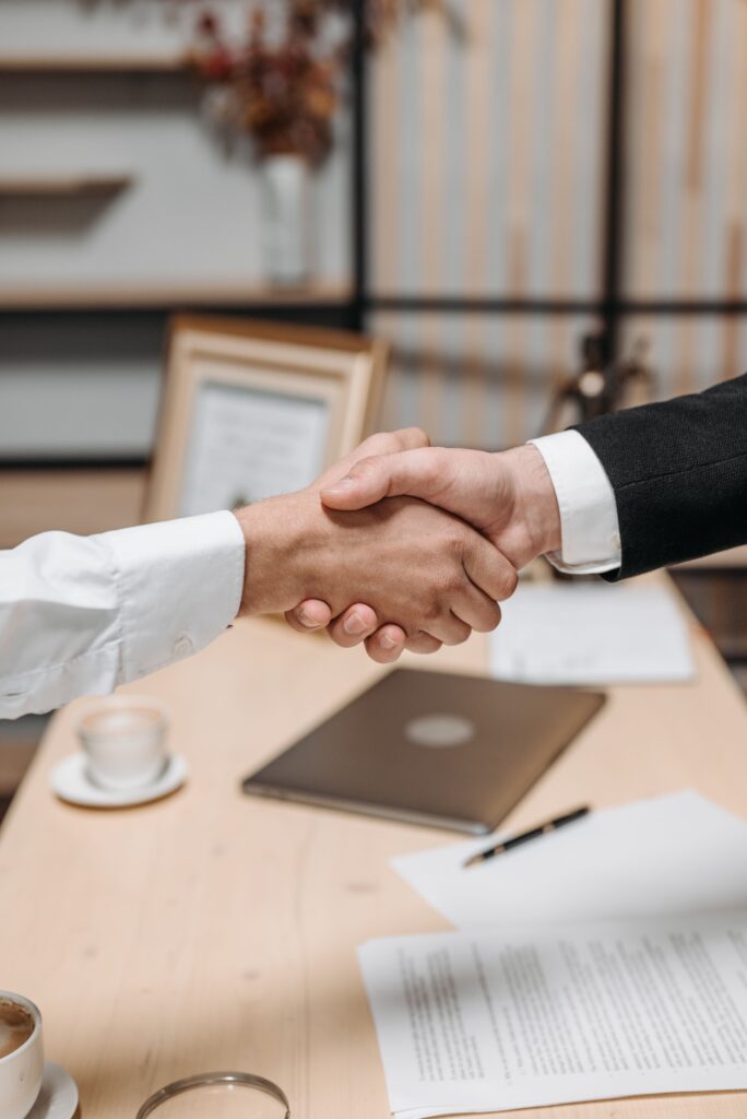 Como Negociar Dívidas com Bancos: cliente e representante financeiro fechando um acordo após renegociação de dívidas.