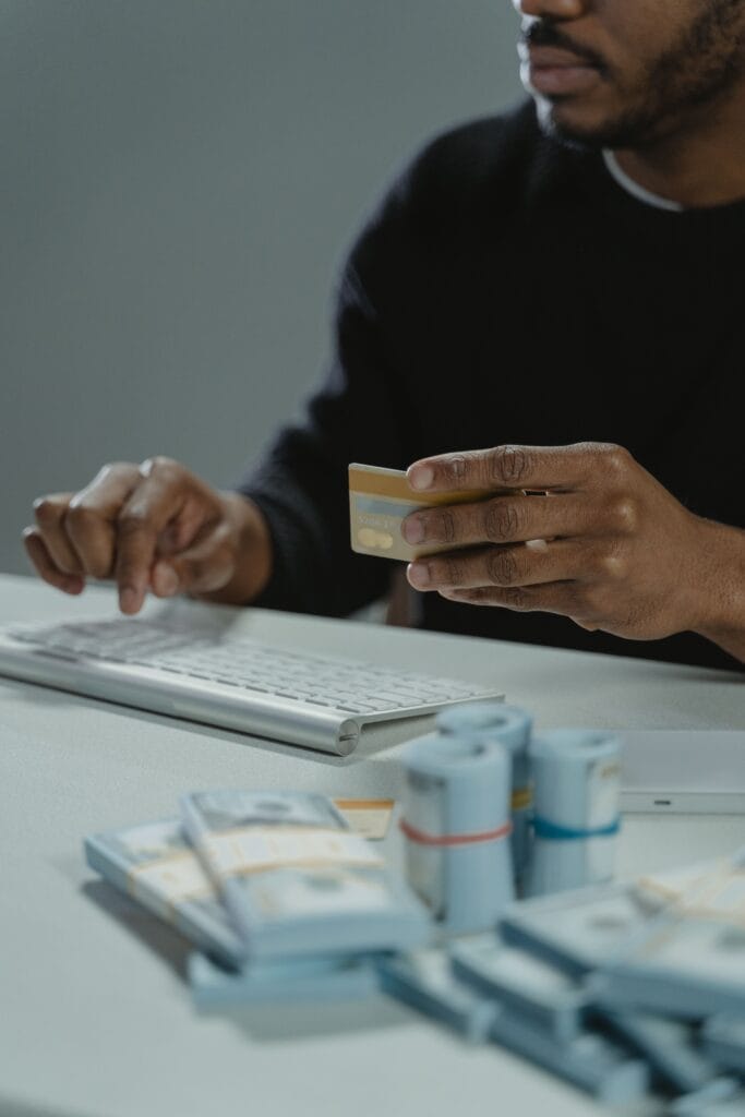 Homem olhando o cartão de crédito enquanto verifica o aumento do limite no aplicativo do banco.