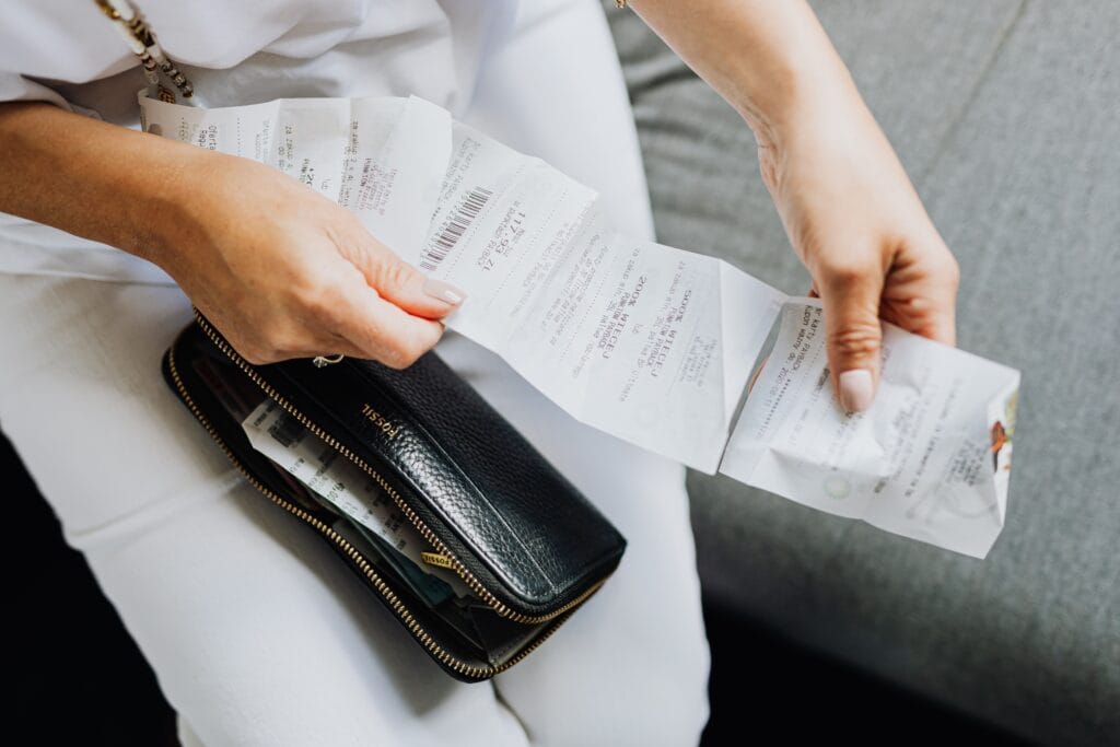 Pessoa analisando recibos e despesas para entender como a inflação afeta o orçamento familiar e o poder de compra.