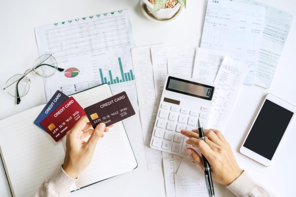 Pessoa organizando gastos do cartão de crédito pelo celular durante planejamento financeiro