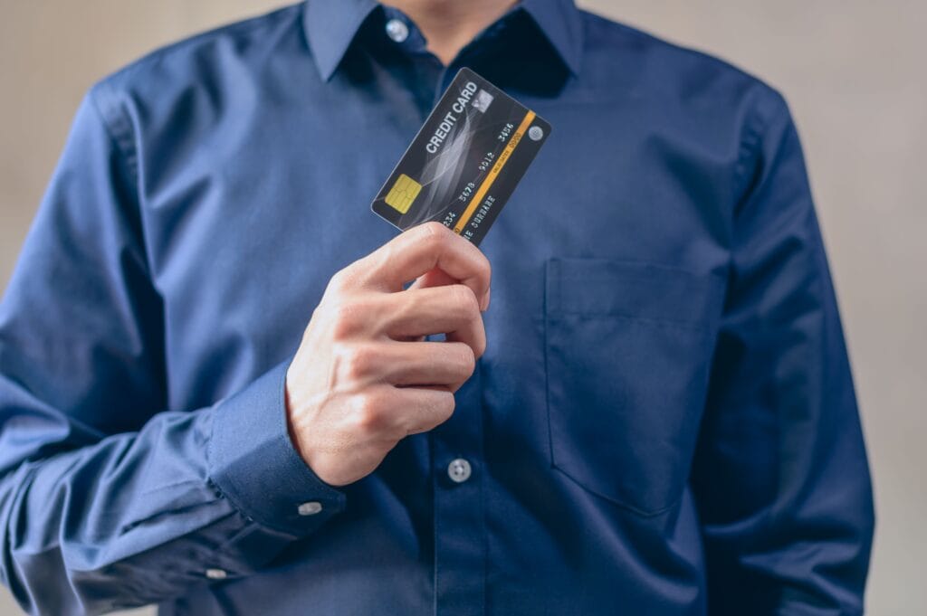 Pessoa usando cartão de crédito para realizar uma compra em 2026