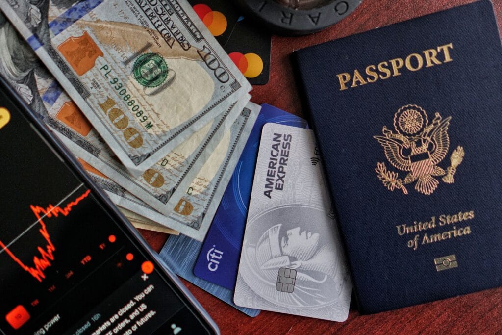 Cartão de crédito internacional ao lado de passaporte e dólares, representando compras internacionais, viagens e pagamentos no exterior.