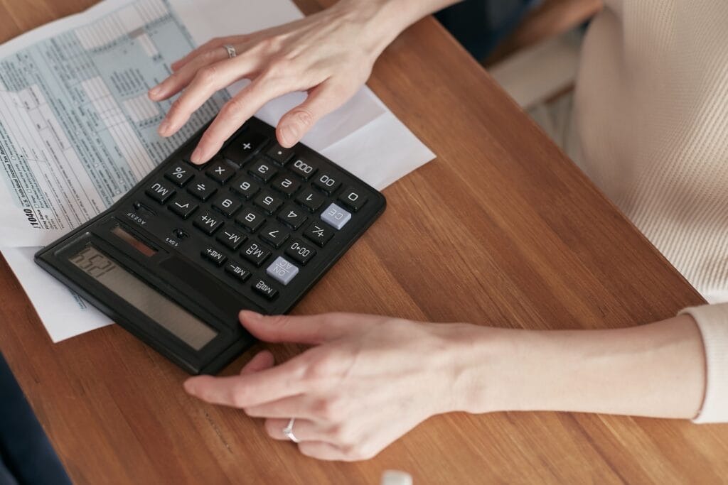 Pessoa analisando contas e calculando valores para renegociação de dívida