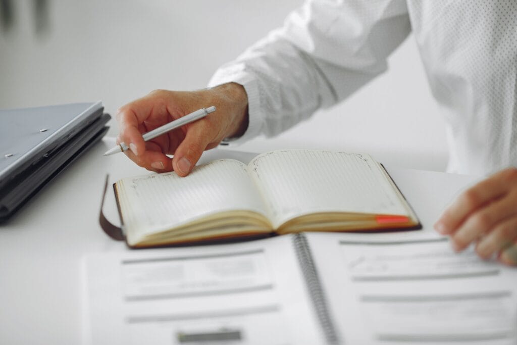 Pessoa organizando um plano financeiro pessoal com notebook e calculadora